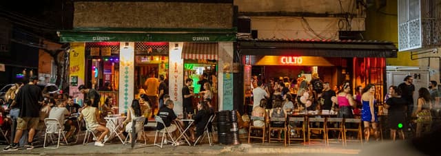 People at outdoor bar tables on a Botafogo street at night, Rio de Janeiro